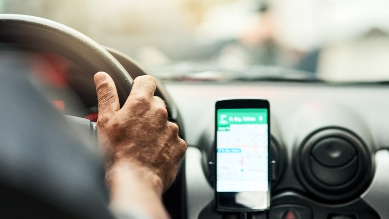 Smartphone op een houder in een auto met de Google Map-app geopend.
